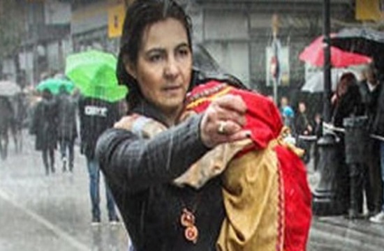 Brave Greek mum defies downpour to march alone holding child in Pyrgos